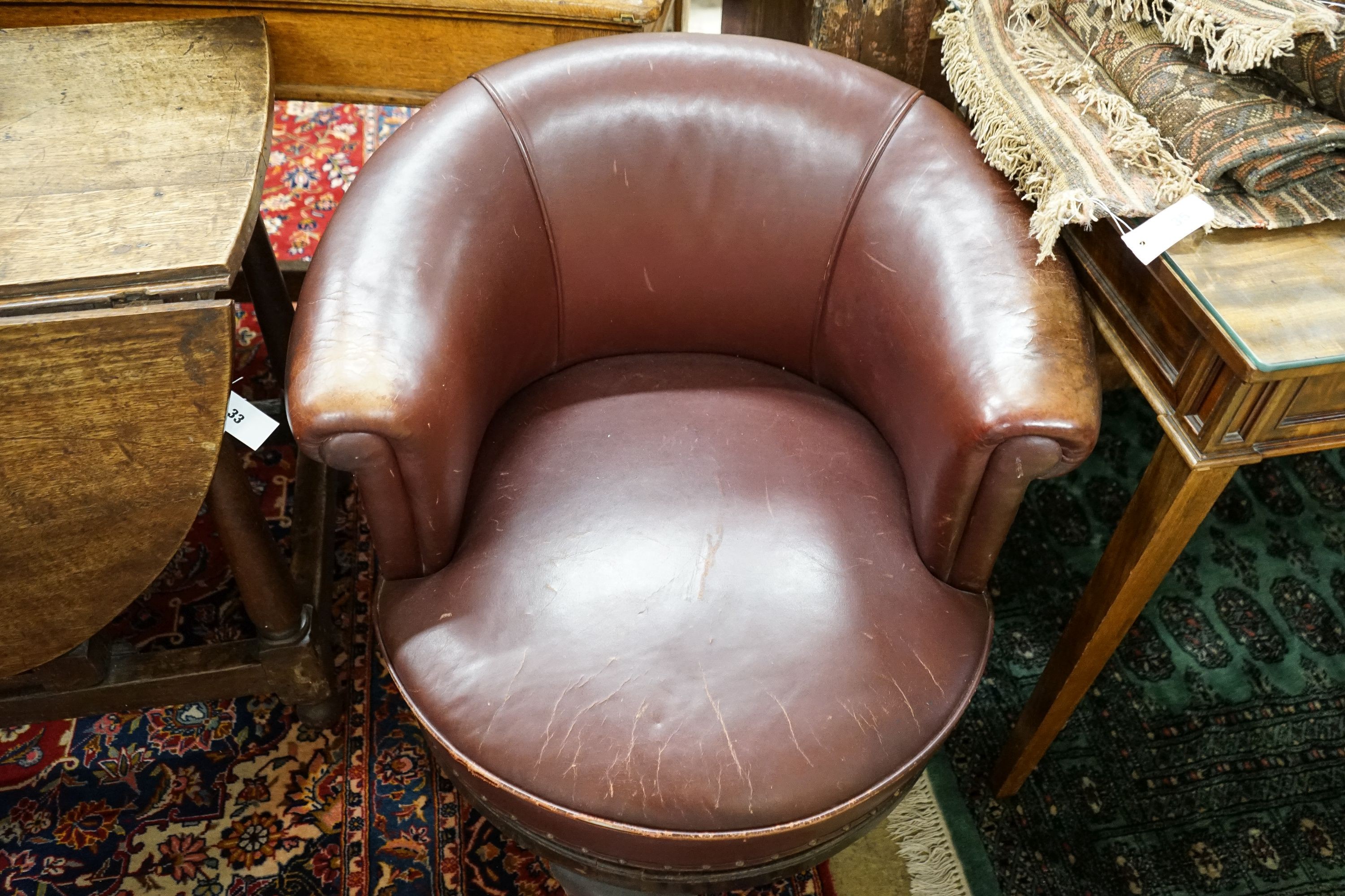 A late Victorian mahogany burgundy leather tub frame swivel desk chair, width 72cm, depth 62cm, height 74cm